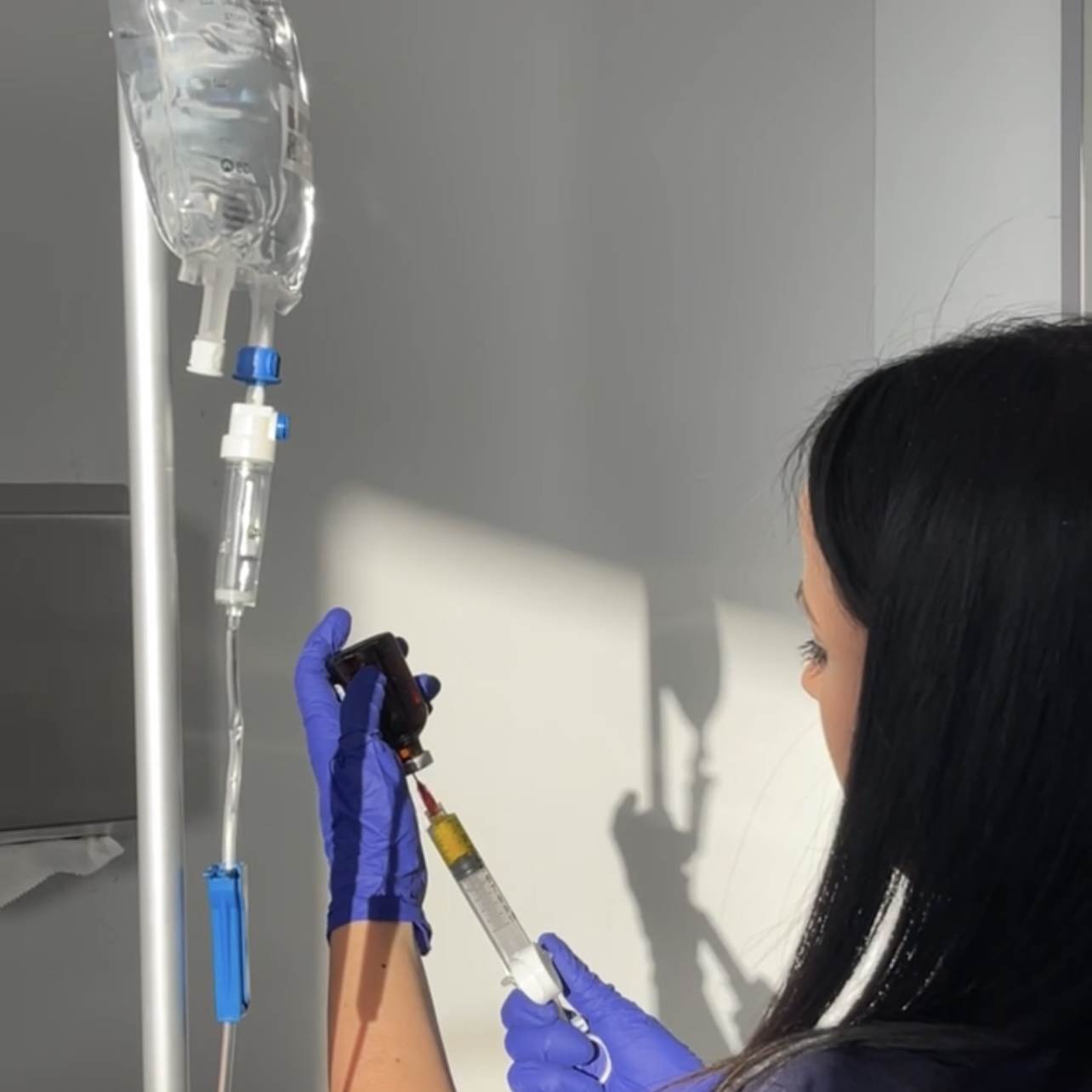 IV nurse filling IV bag from vial