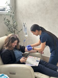  IV Elements nurse administering NAD therapy to client while she works.