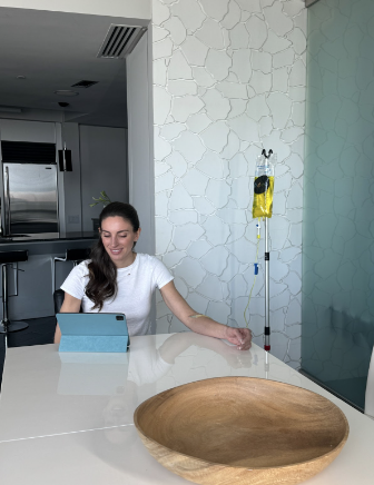 A woman sitting in the Parisppany Drip Lounge while receiving IV therapy