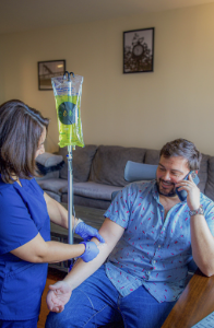 A man talking on the phone as he receives IV therapy