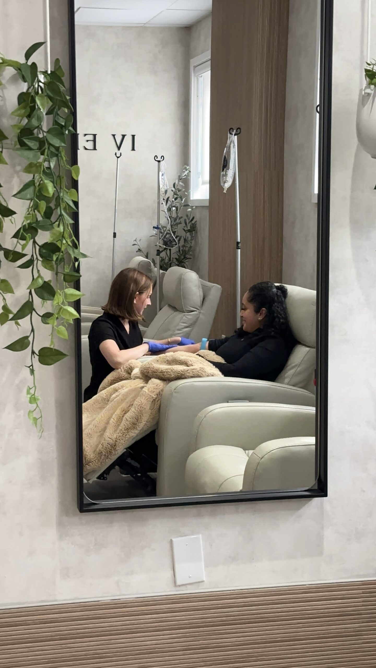 Nurse speaking with patient sitting in chair with blanket