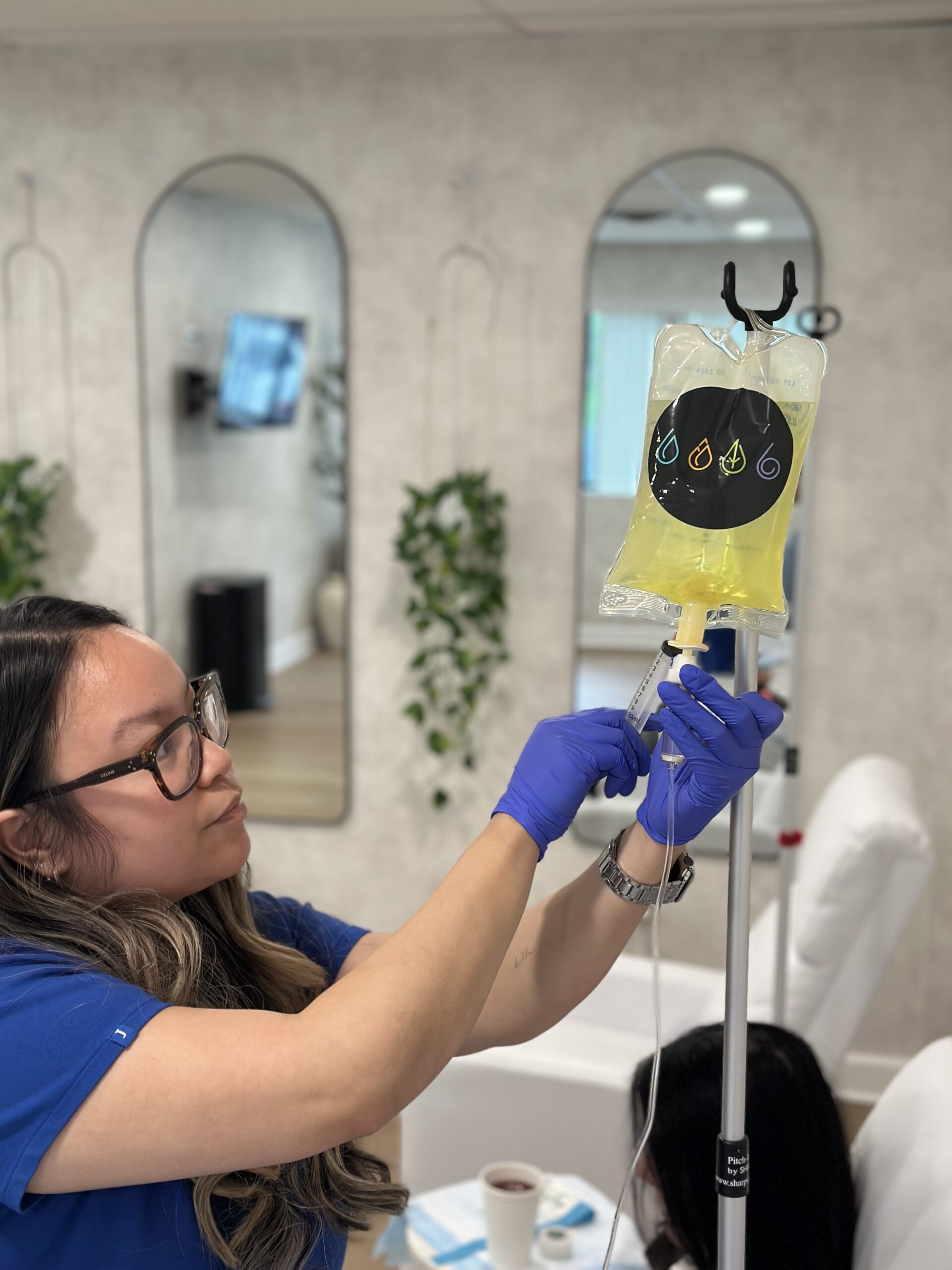 A nurse preparing a yellow IV supplement