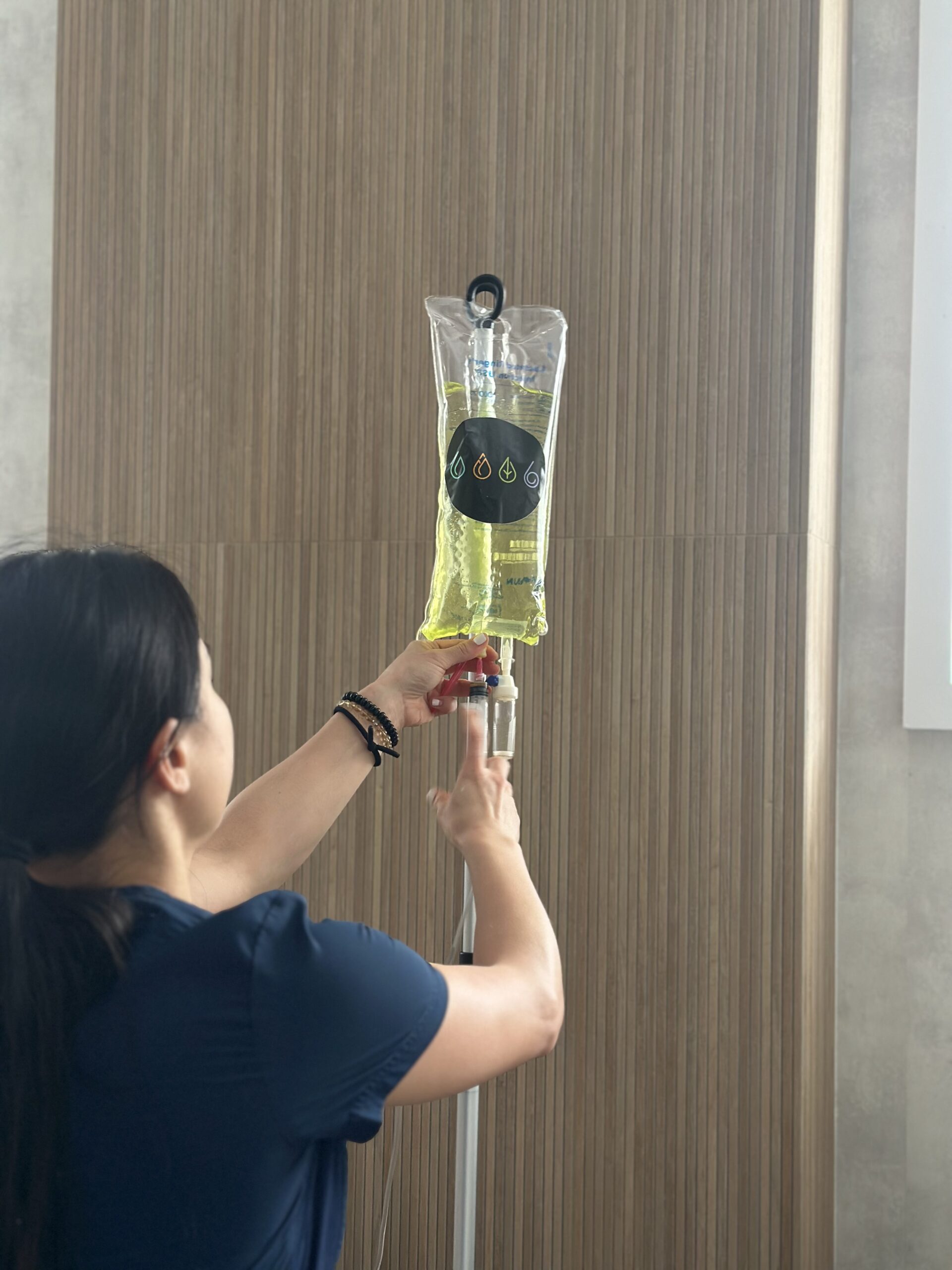 Nurse adding to IV bag with IV Elements logo