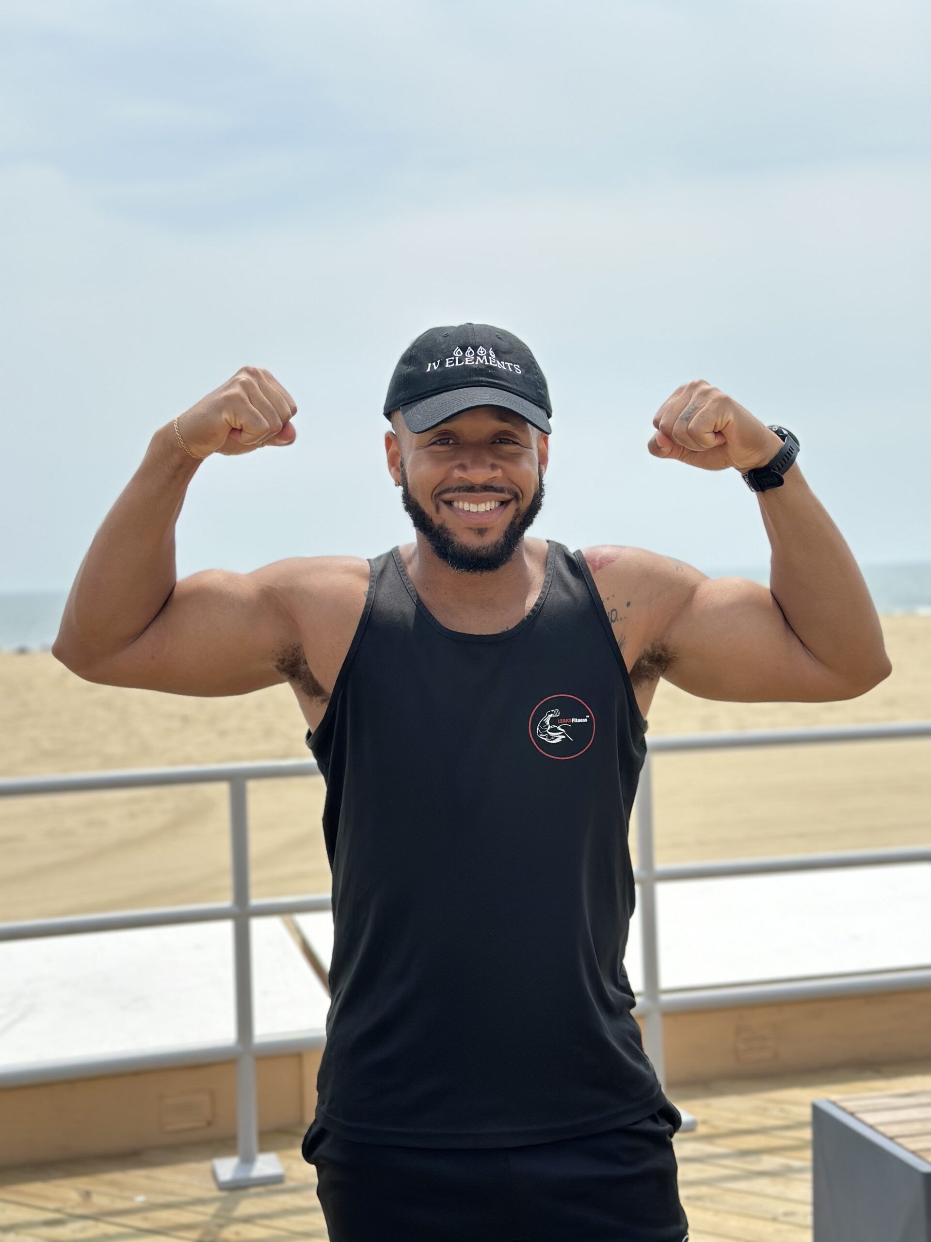 Man flexing arms wearing IV Elements hat.