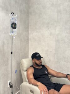 Man receiving IV bag while sitting in a chair