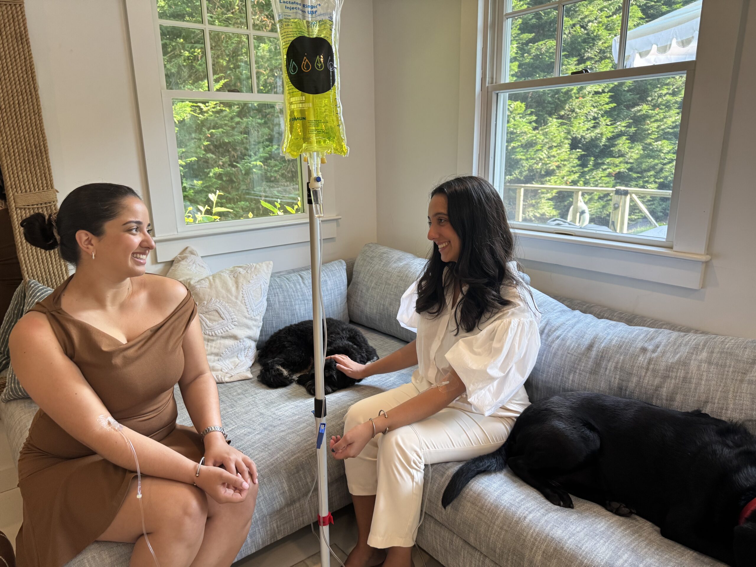 Women sitting on couch talking and receiving IV treatment!