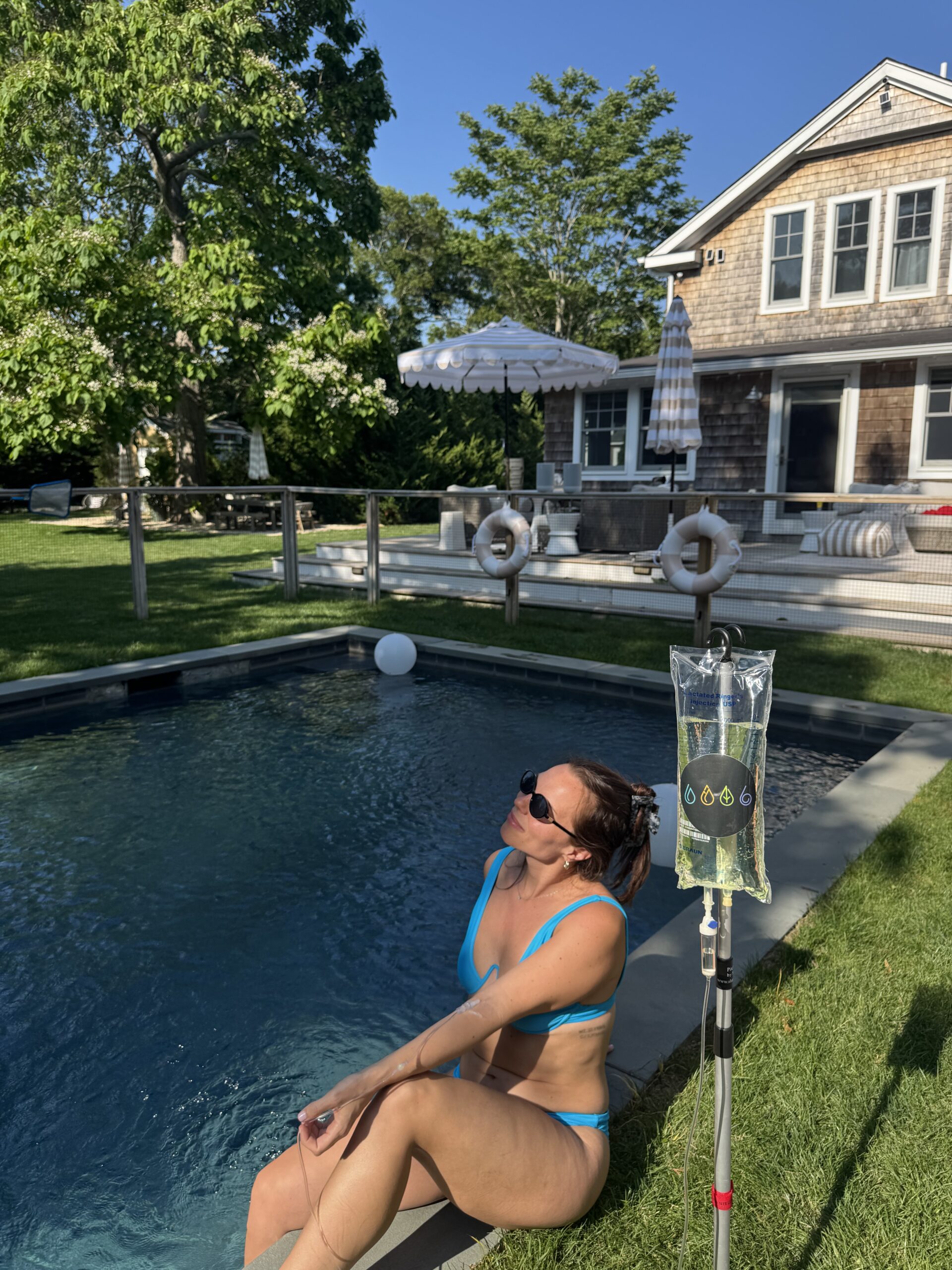 women by the pool receiving IV treatment.