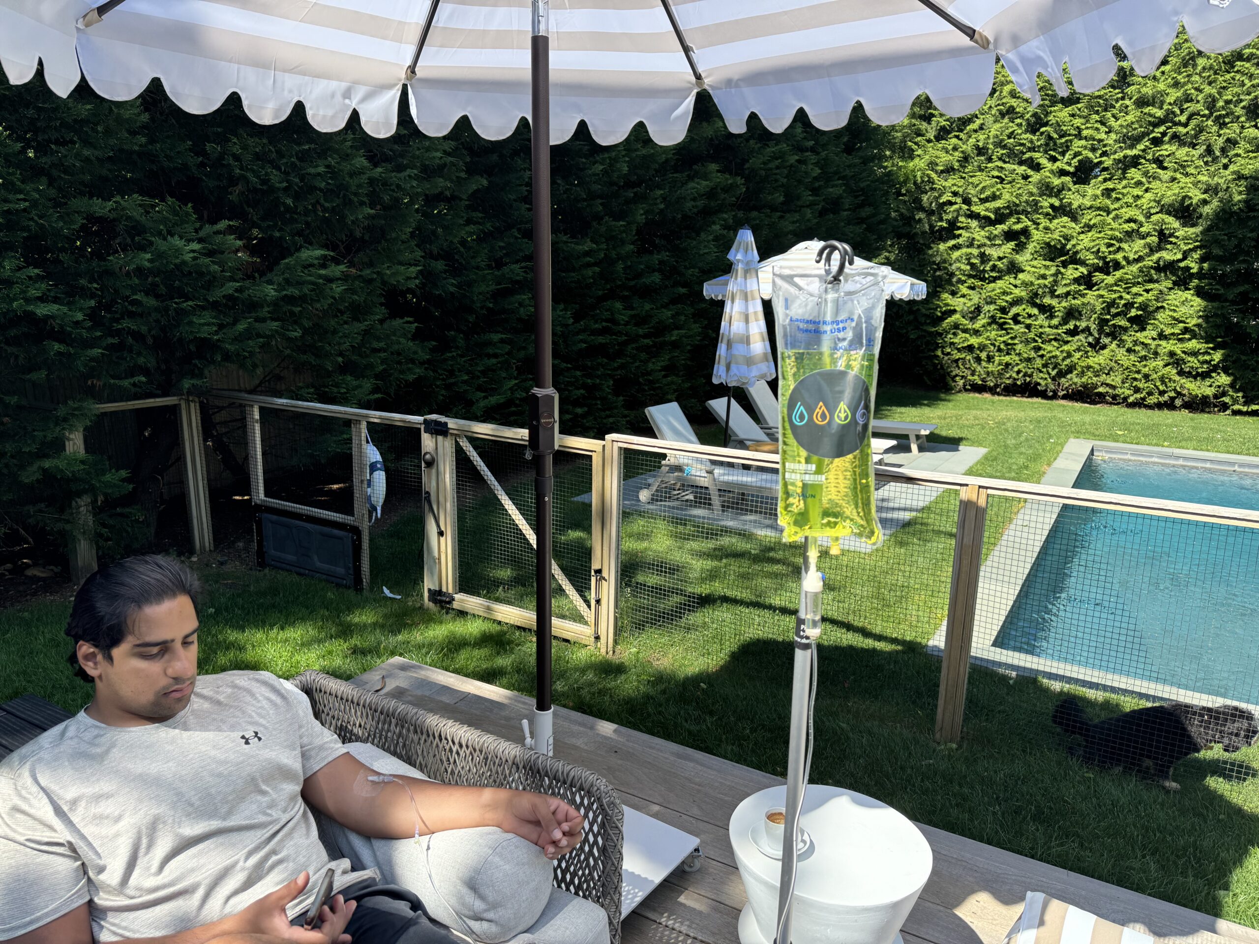 Man receiving IV Treatment near pool.