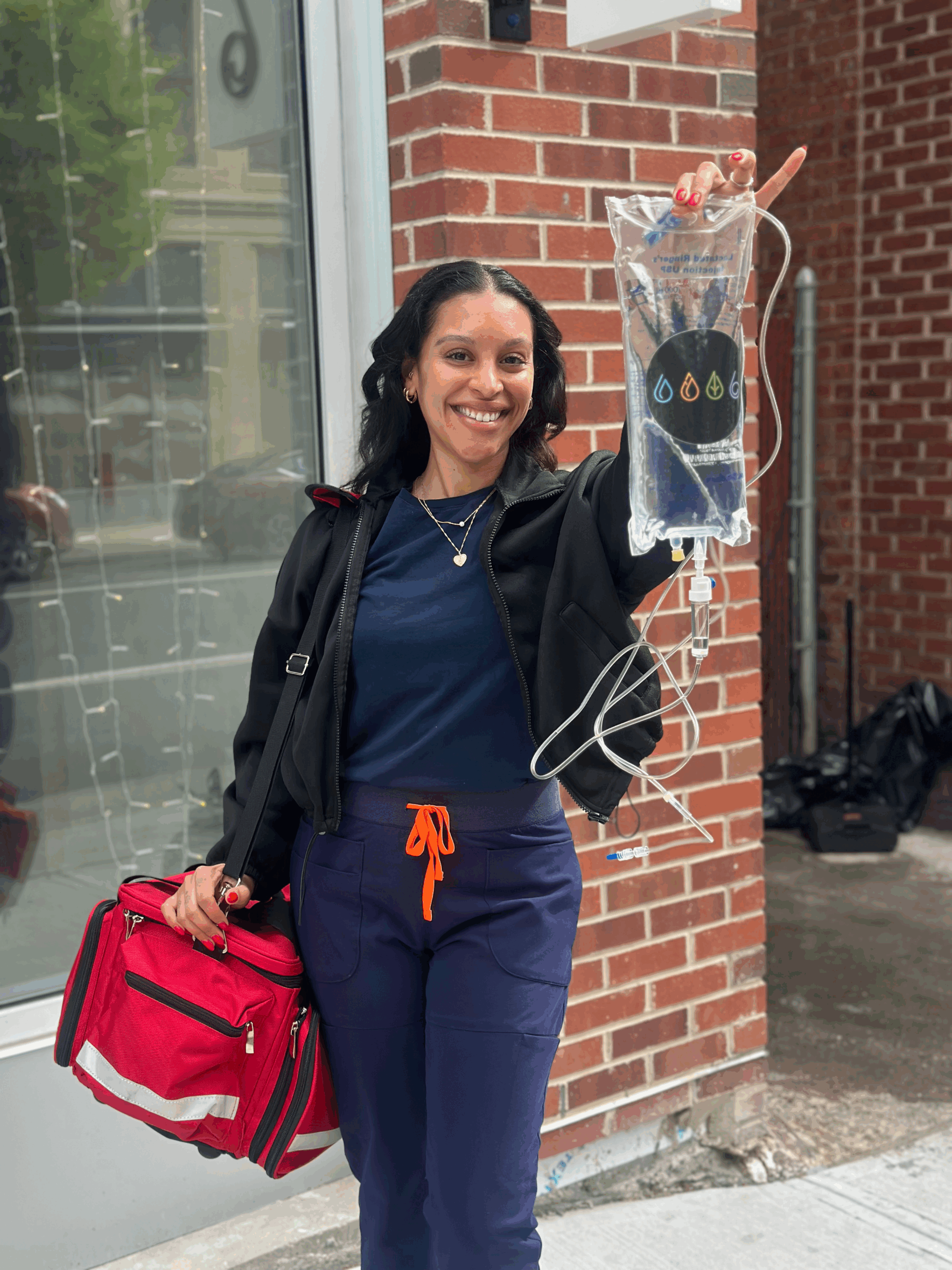 Nurse holding IV bag and travel bag