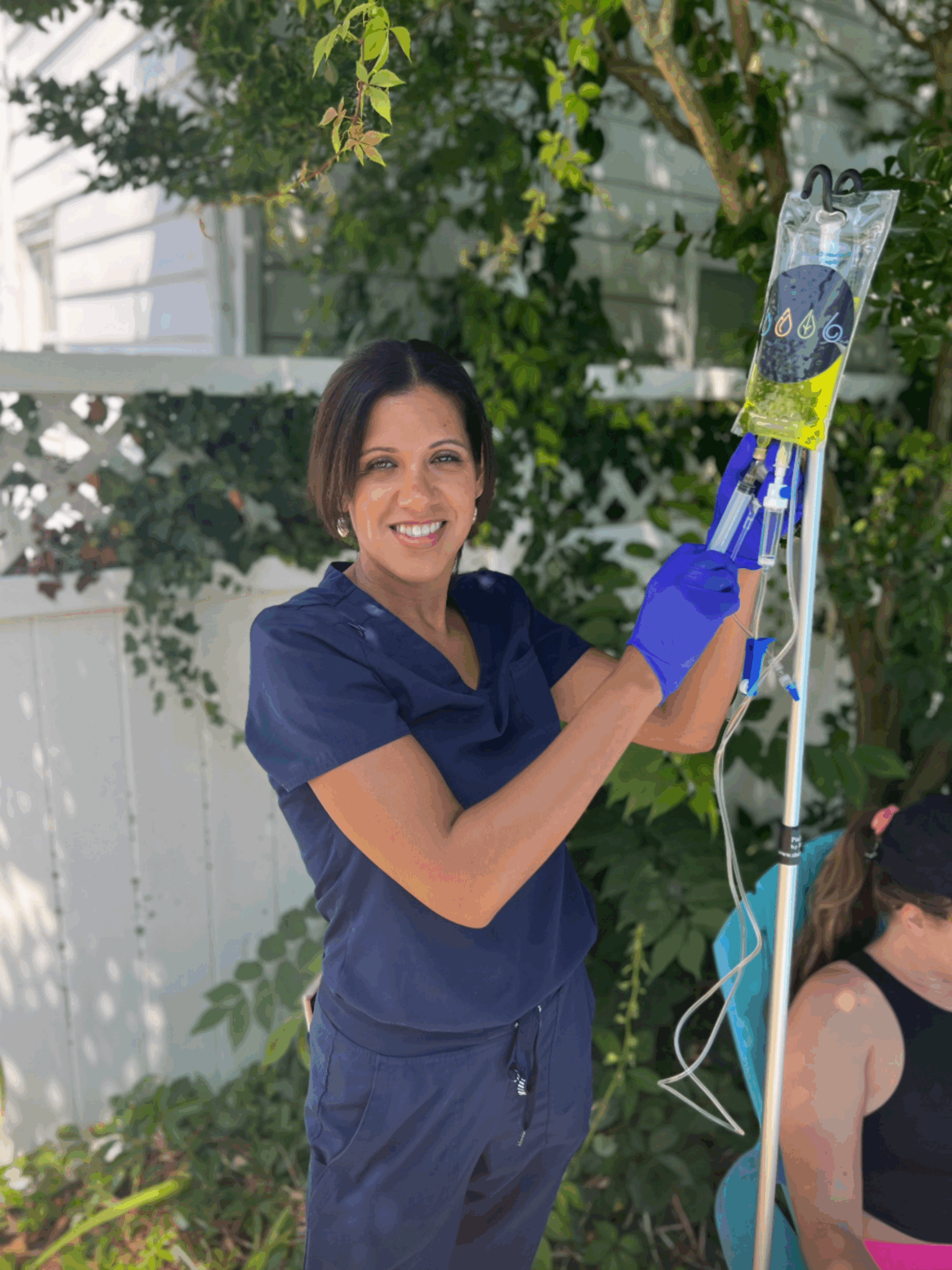 Female nurse adding vitamins to IV bag.