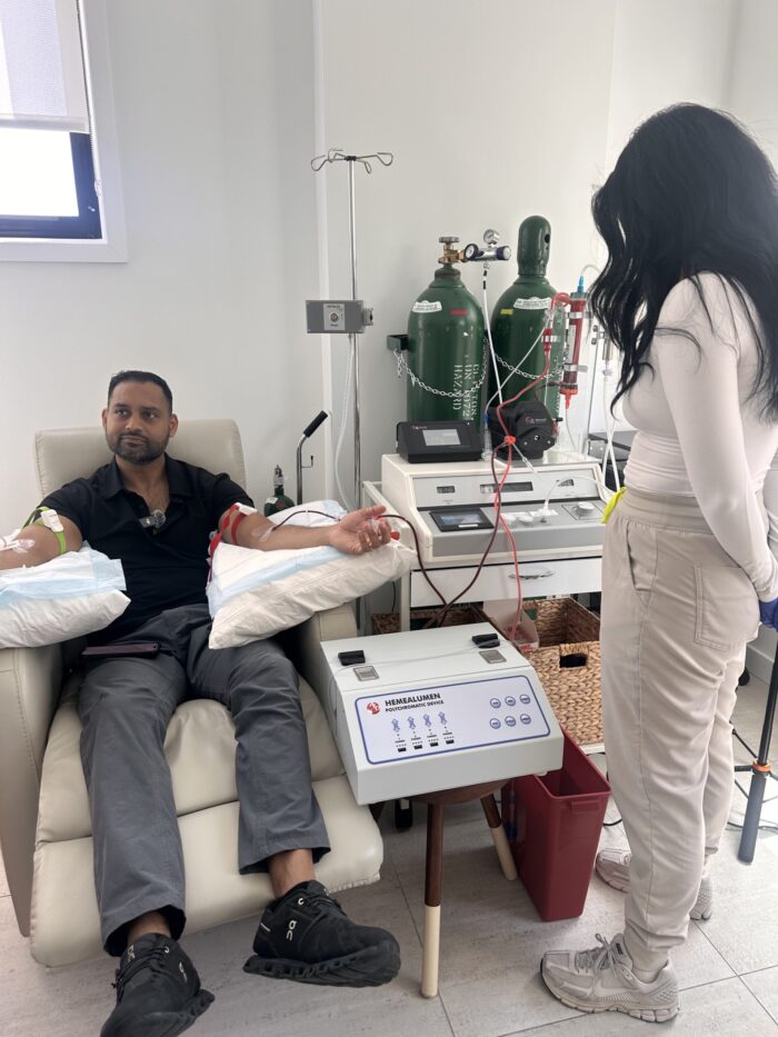 Client relaxing while receiving EBOO treatment from IV Elements nurse
