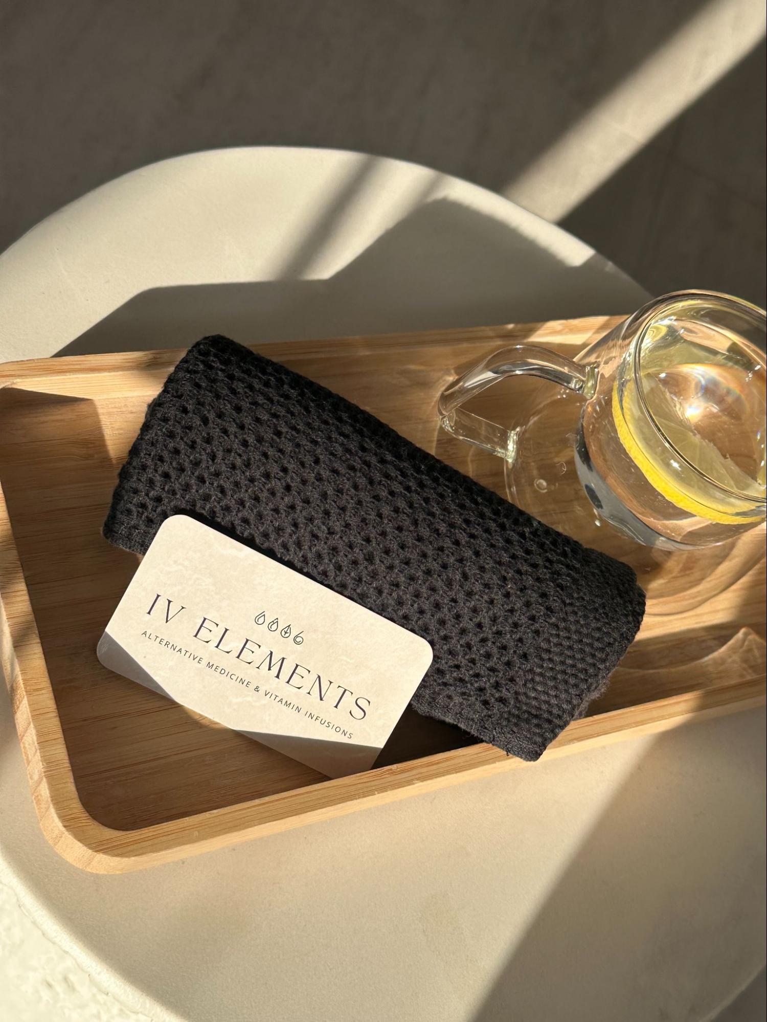 Above image of lemon water, towel, and IV Elements business card