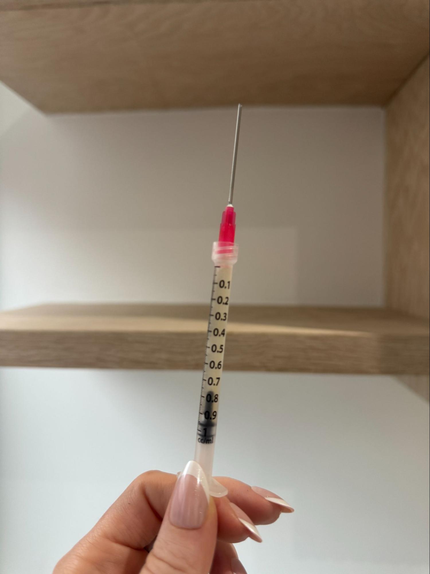 IV Elements nurse holding tirzepatide injection in front of plant.